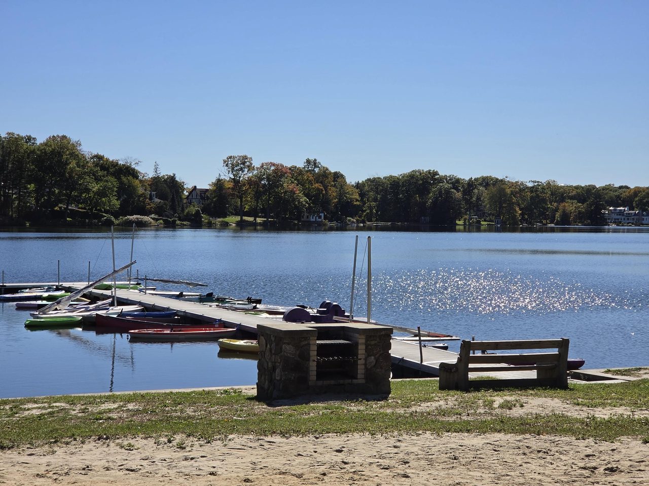 The dock at Island Beach in Mountain Lakes, with boats on the lake and lakefront homes across the water